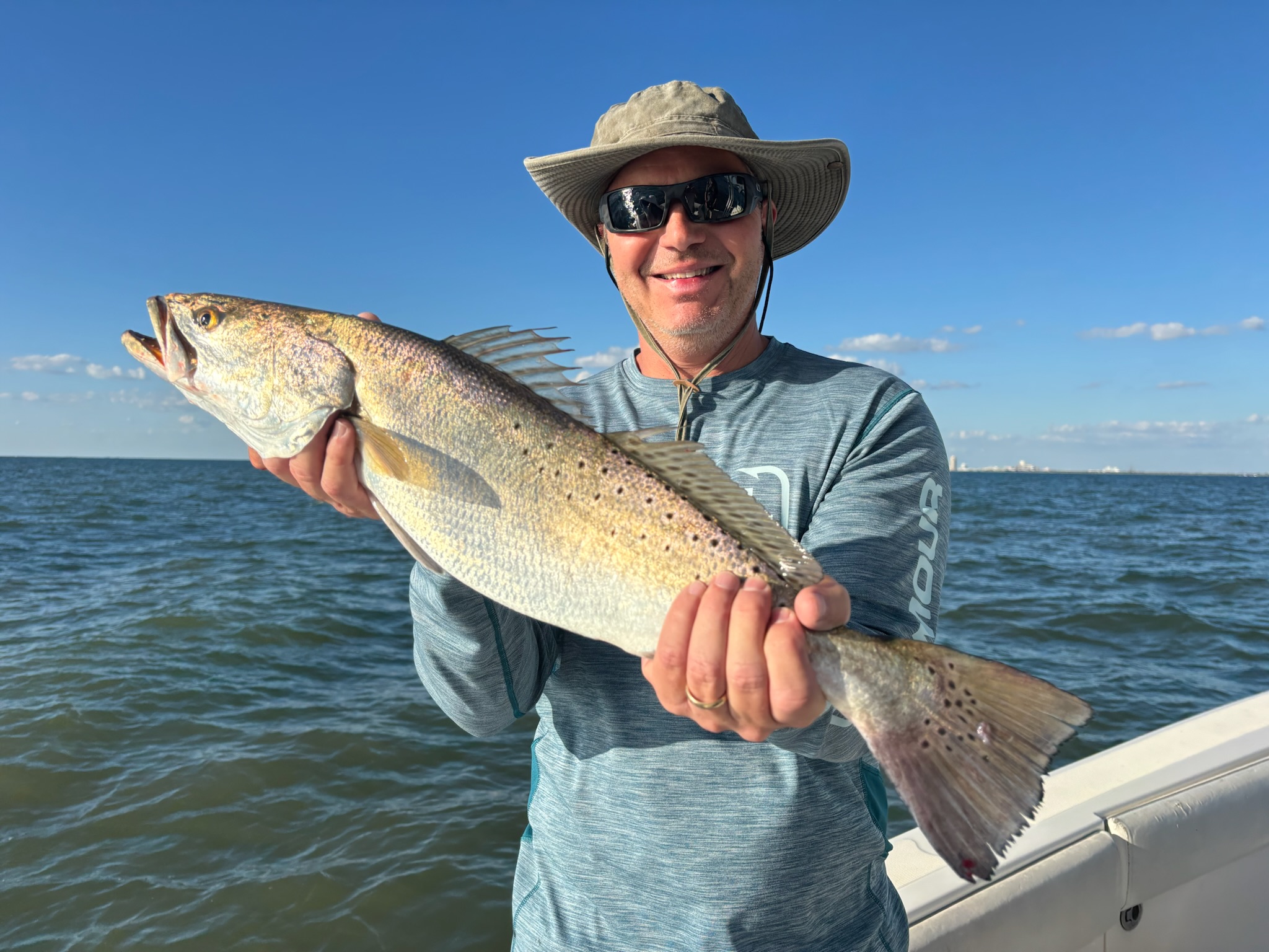 Angler holding speckled trout caught on Galveston Bay fishing charter